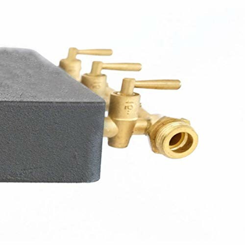 Bloc de vannes en laiton attaché à un objet métallique.